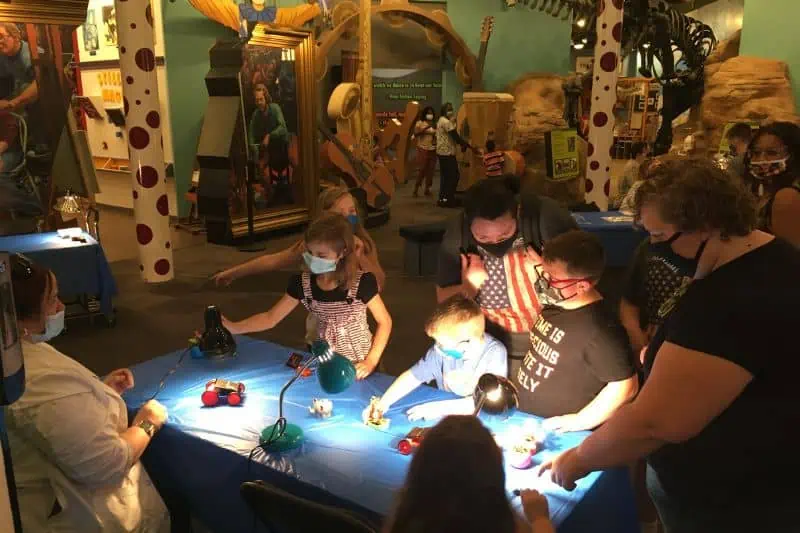 solar installation at science museum with children gathered around an exhibit.
