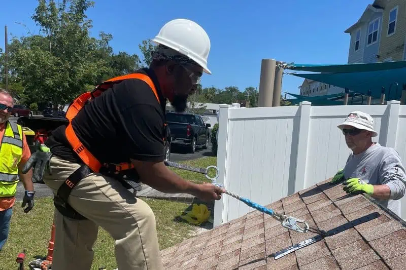 nonprofit solar installation with worker on roof installing solar mounts
