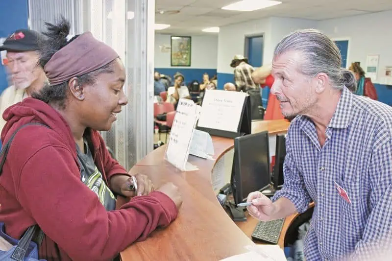man at a desk talking to a women at St Francis Center