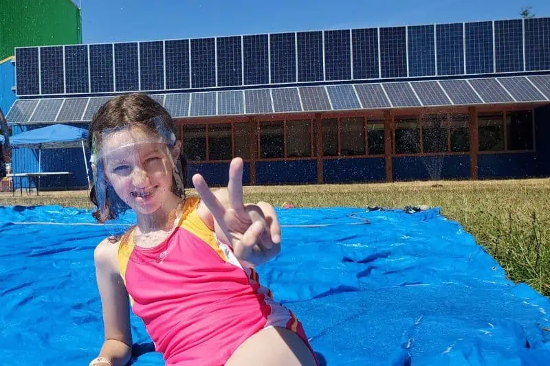 young girl in a pink and yellow bathing suit on a blue tarp