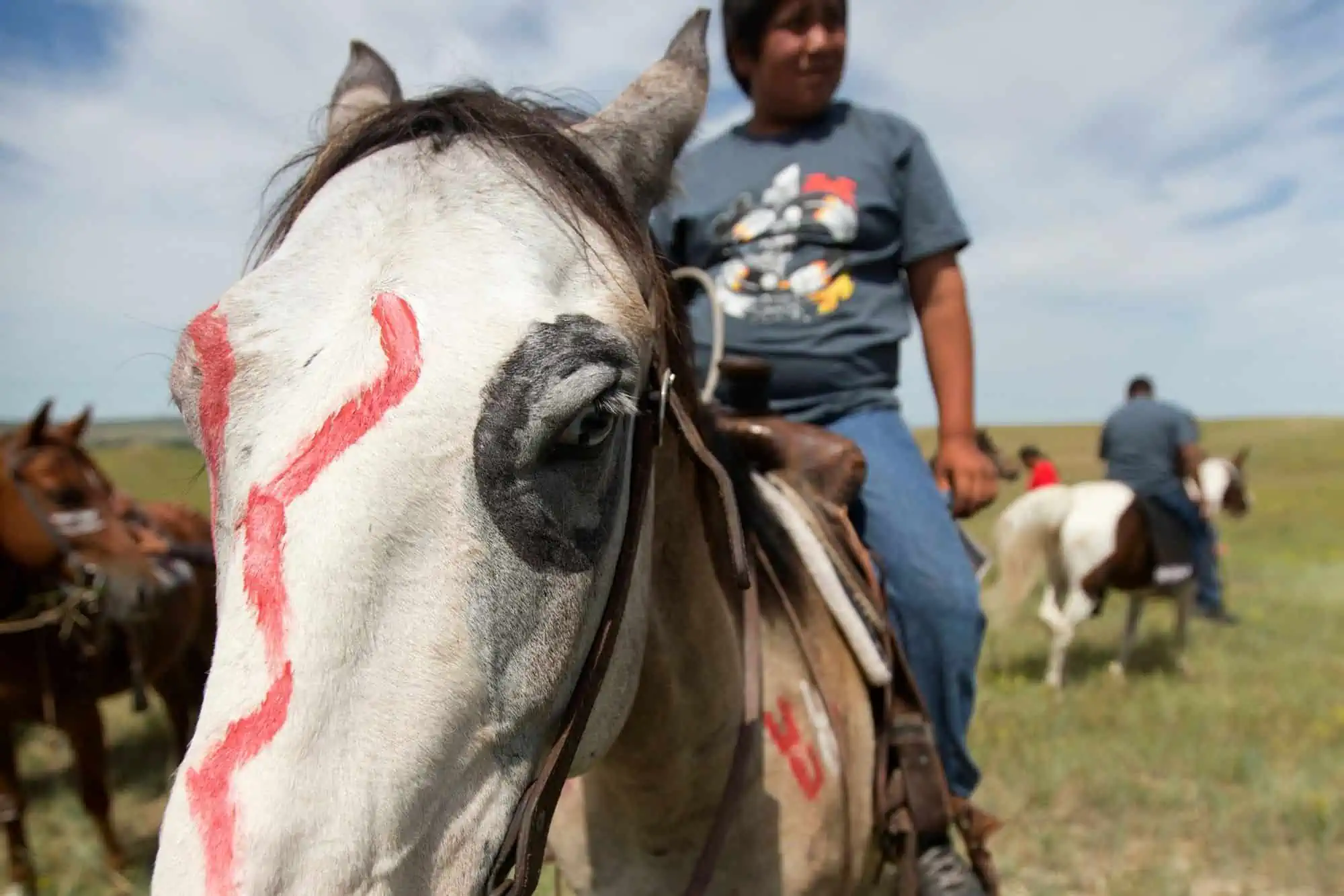 man riding a horse with red pain on it