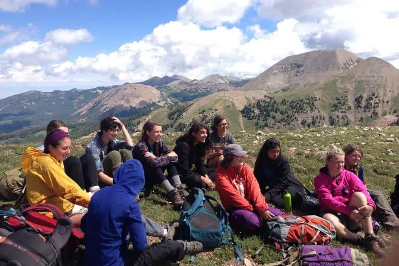 group of backpackers sitting by a mountain
