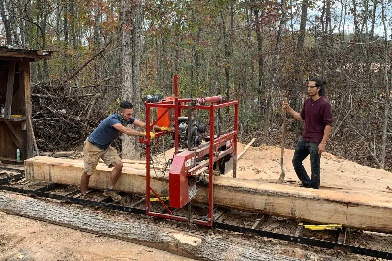two men working on a log