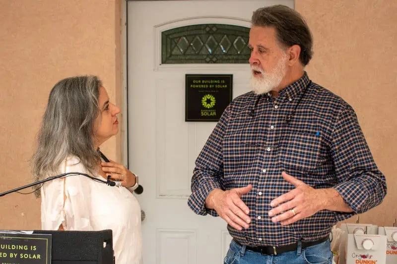 Man talking with woman about solar for St Johns Housing Partnership.