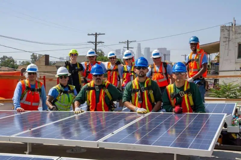 group of workers standing around a solar panel