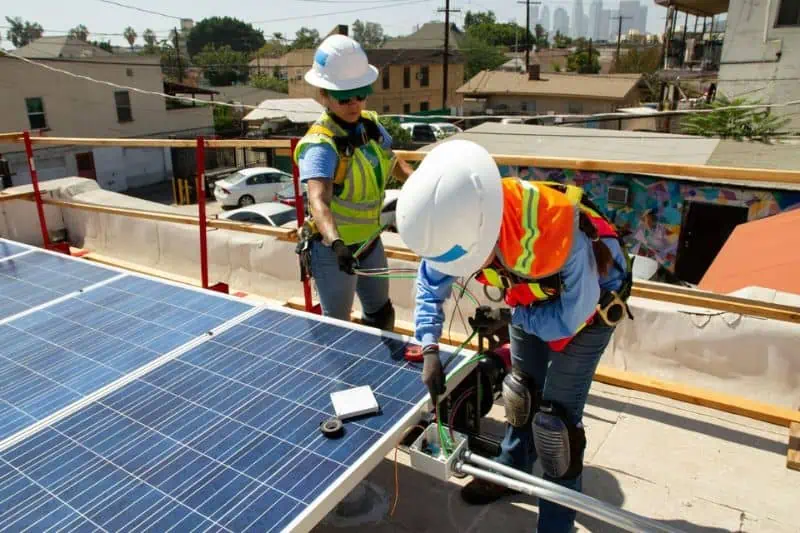 men installing solar panels on a roof