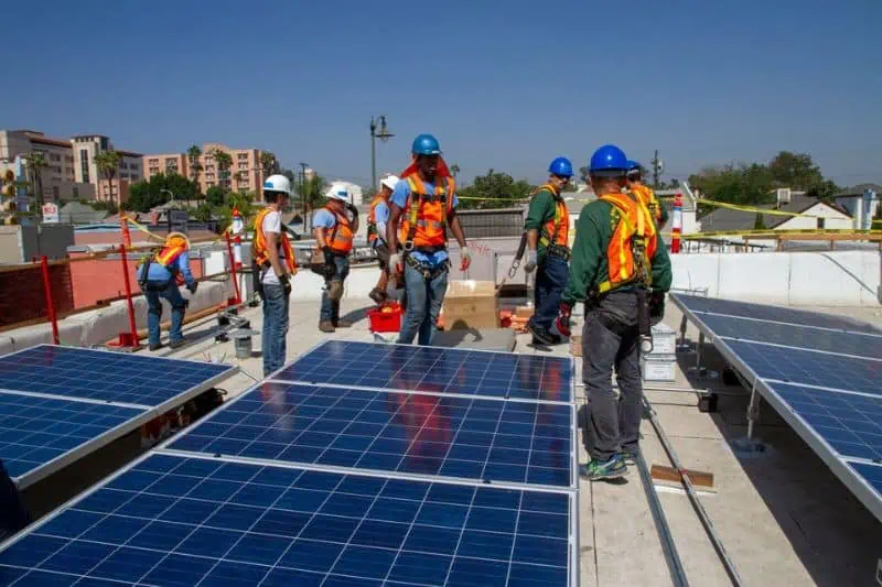 group of people working to install solar panels
