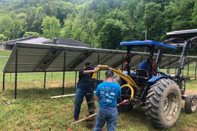 two workers doing ground work to install solar