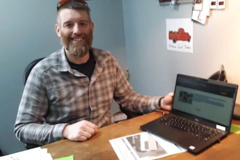 man smiling while sitting at computer working