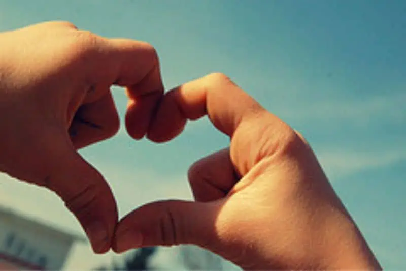two hands with the fingers shaped into a heart