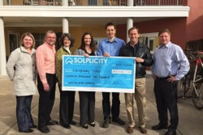 people holding a check for donation
