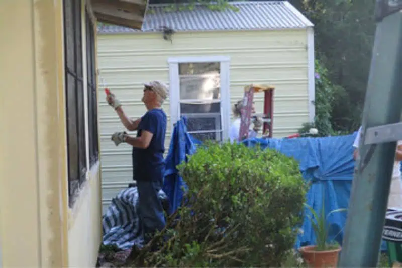 man painting the outside of a house