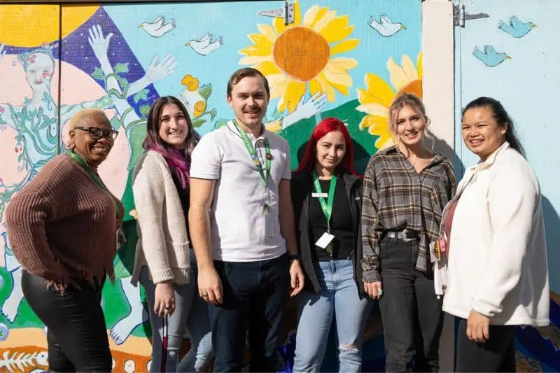 group of people in front of mural