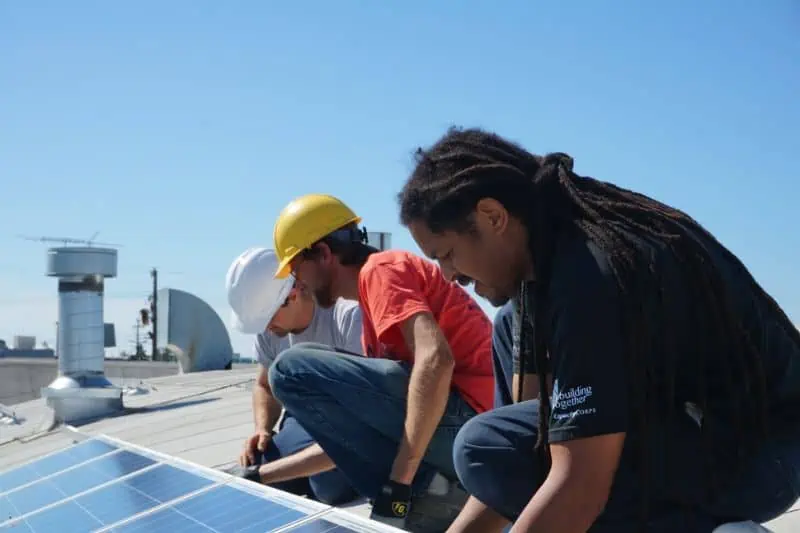 volunteers checking a solar panel
