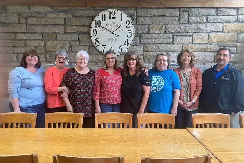 group of people standing behind a table