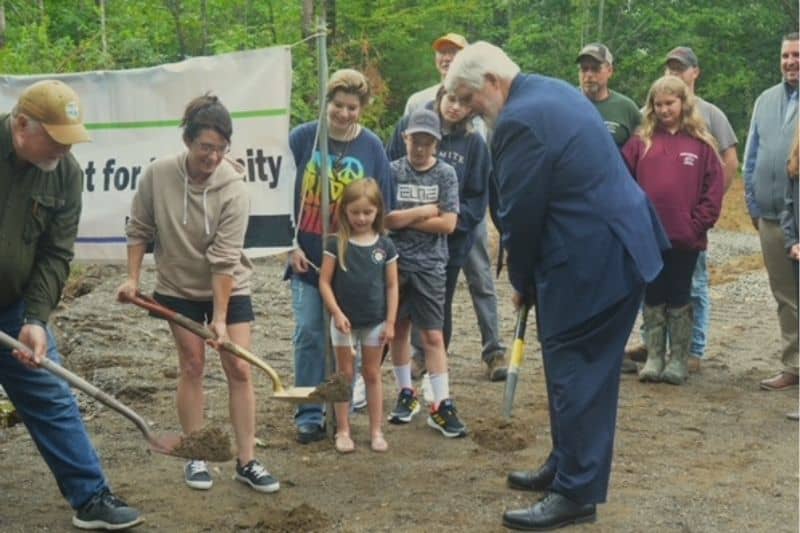 People breaking ground at project site with shovels.